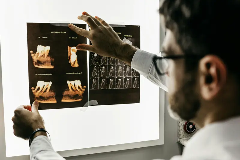 Dentista revisa imágenes radiológicas dentales en un negatoscopio