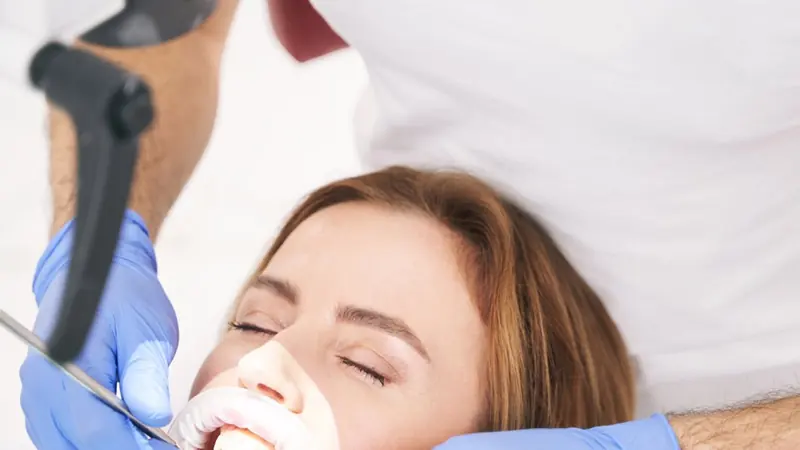 Odontólogo trata a una paciente en el sillón dental