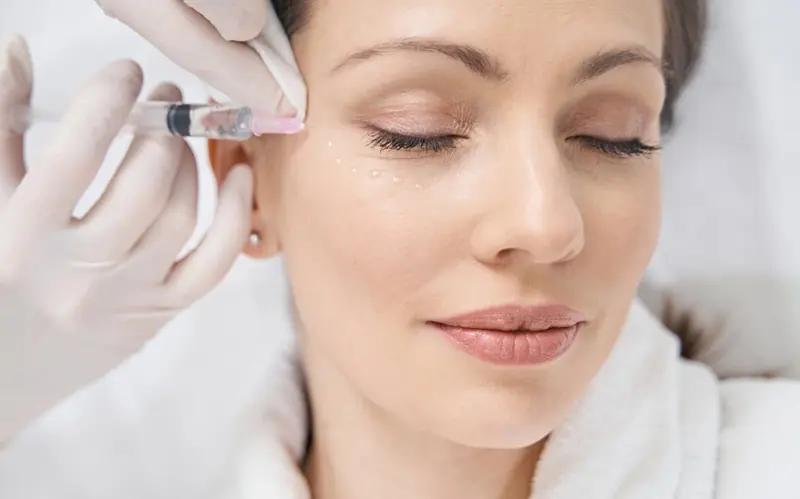 Mujer relajada con los ojos cerrados durante un tratamiento facial