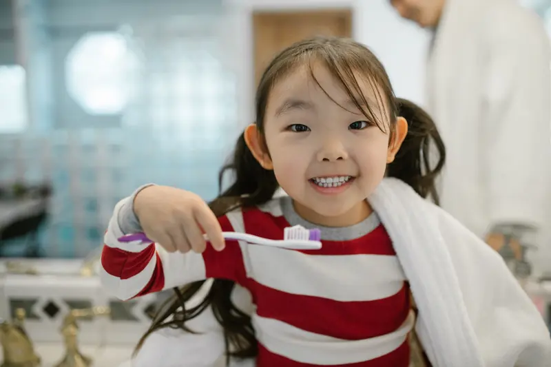 Niña sonriente con su cepillo de dientes
